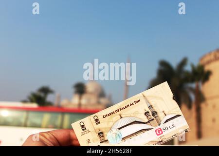 Cairo, Egypt - 12.08.2010: I am holding the tickets for Citadel of Salah Al-Din visit with the price on it, and the Citadel itself on the background Stock Photo