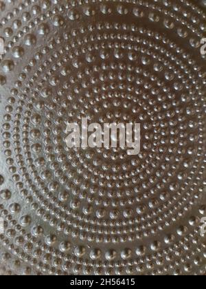 Metal plate with balls of various sizes, forming circles, in golden color, Full screen, top view. Stock Photo