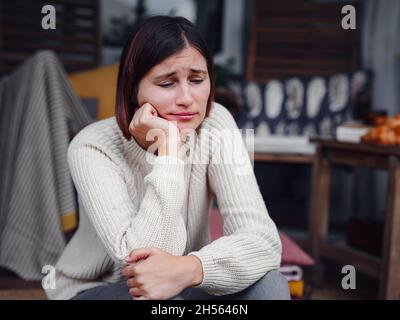 Young depressed asian woman sitting on porch of backyard. She feeling sad and worried suffering depression in mental health. Mental health, anxiety de Stock Photo