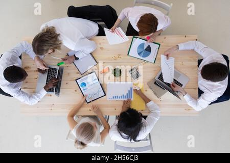 Business people brainstorming at office desk analyzing financial reports and pointing out financial data on documents, top view Stock Photo