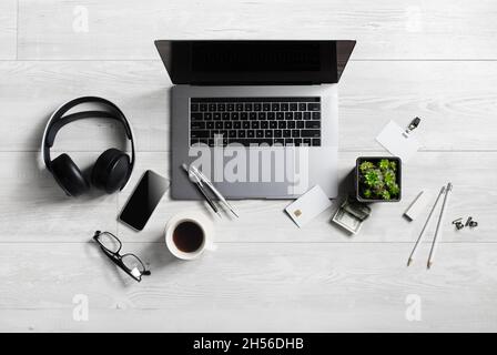 Office workspace with supplies and gadgets on wooden background. Flat lay. Stock Photo