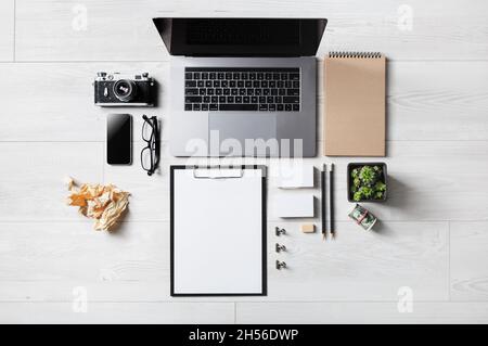 Mix of blank office supplies and gadgets on wooden background. Flat lay. Stock Photo