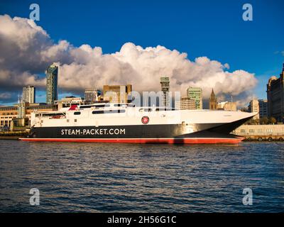 The Isle of Man ferry HSC Manannan moored at Liverpool on a sunny day with modern office and apartment buildings behind. The ferry was built by Incat Stock Photo