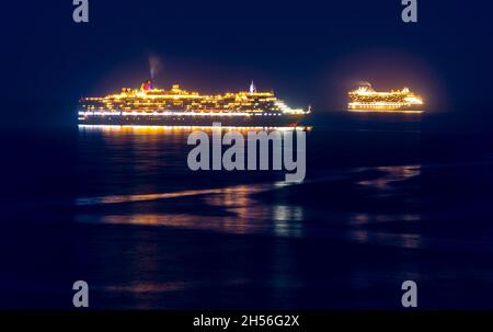 During Covid lockdown, brightly lit cruise liners are moored for months in Weymouth Bay Stock Photo