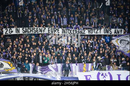 07 November 2021, Saxony, Aue: Football: 2. Bundesliga, Erzgebirge Aue - 1. FC Heidenheim, Matchday 13, Erzgebirgsstadion. Aue's fans hold up a banner '2G in Saxony? Your intolerance pisses us off!!!'. Photo: Robert Michael/dpa-Zentralbild/dpa - IMPORTANT NOTE: In accordance with the regulations of the DFL Deutsche Fußball Liga and/or the DFB Deutscher Fußball-Bund, it is prohibited to use or have used photographs taken in the stadium and/or of the match in the form of sequence pictures and/or video-like photo series.