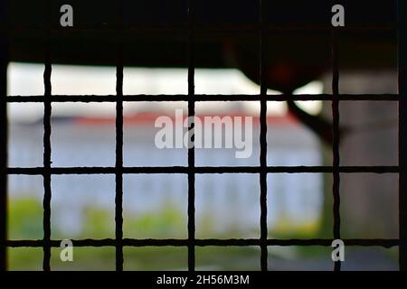 Metal grate in window opening on blurred colored background Stock Photo