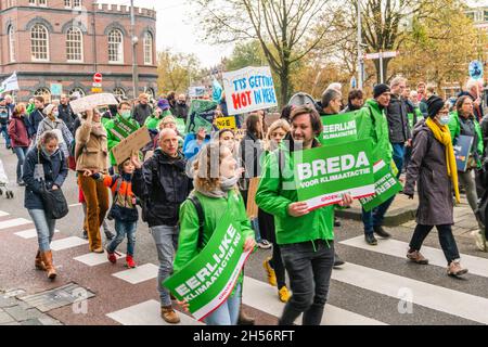 Amsterdam, Netherlands, November 06, 2021. Participants representing GroenLinks (political party) carry signs and banners with texts like 'Honest climate action NOW' and 'It's getting HOT in here' during the Climat March. Credit: Steppeland/Alamy Live News Stock Photo