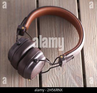 Bluetooth headphones over wooden table, horizontal image Stock Photo