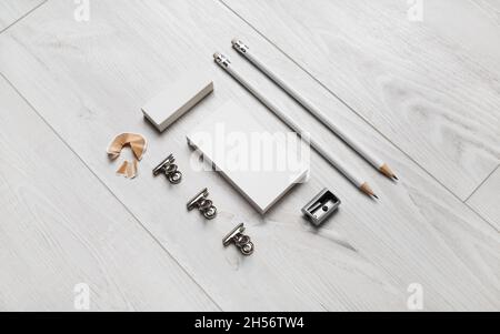 Blank business card, pencils, eraser and sharpener on wooden background. Blank branding identity set. Stock Photo