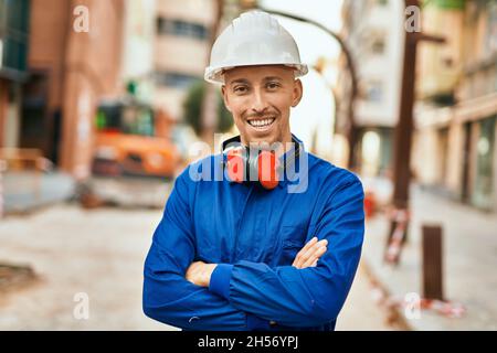 Young caucasian worker smiling happy wearing uniform at the city. Stock Photo