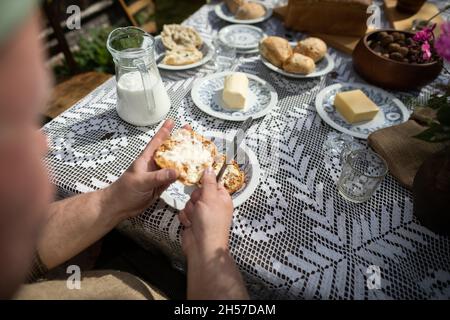 A man while spreading butter on a roll. A country breakfast. Stock Photo