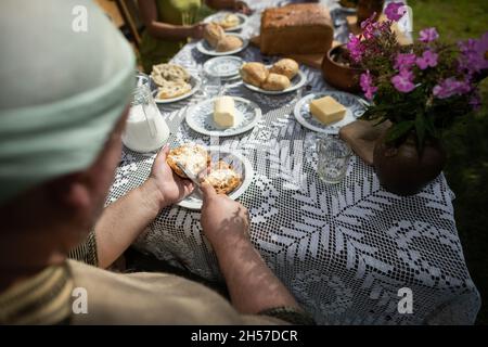 A man while spreading butter on a roll. A country breakfast. Stock Photo