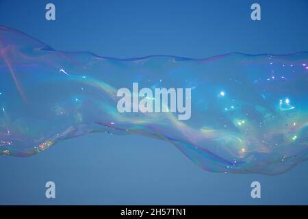 Giant colourful soap bubble stretching across the blue sky Stock Photo