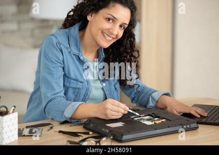 female engineer repairs laptop support fixing notebook computer Stock Photo