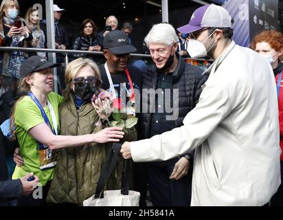 New York, United States. 07th Nov, 2021. After crossing the finish line Chelsea Clinton receives flowers from husband Marc Mezvinsky while standing with parents Hillary and Bill Clinton as well as marathon director Ted Metellus at the NYRR TCS New York City Marathon in New York City on Sunday, November 7, 2021. Over 50,000 runners from New York City and around the world race through the five boroughs on a course that winds its way from the Verrazano Bridge before crossing the finish line by Tavern on the Green in Central Park. Photo by John Angelillo/UPI Credit: UPI/Alamy Live News Stock Photo