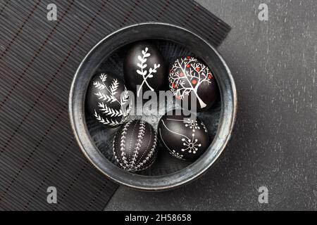 Black monochrome Easter greeting card with handmade wax dyed pysanka eggs in a bowl Stock Photo