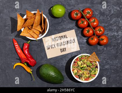 The ingredients for making Spicy Guacamole are avocado, red onion, tomato, chili, lime, cilantro, and garlic. National Guacamole Day. Stock Photo