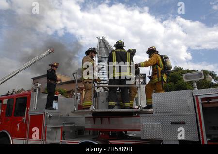 San Diego City Fire Fighters on the stick working a structure fire in San Diego, California Stock Photo