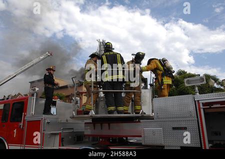 San Diego City Fire Fighters on the stick working a structure fire in San Diego, California Stock Photo