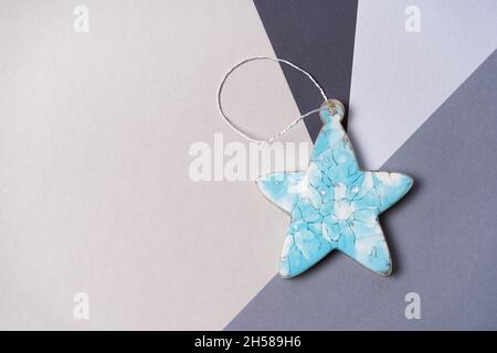 Blue star made from epoxy resin on a gray background. Christmas decorations on the tree. Copy space Stock Photo