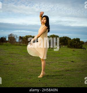 Woman in a Dress Doing Ballet Poses in the Marshlands Stock Photo