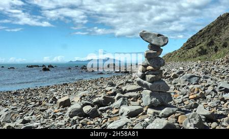 A rock stack on the Kapiti coast beach track between Pukerua Bay and Plimmertion. Kapiti Island offshore Stock Photo