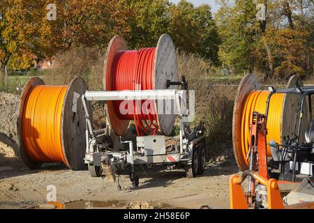 Large reels of new fiber optic cable in red and orange, expansion of high-speed Internet in rural regions. Garbsen Berenbostel, Germany. Stock Photo