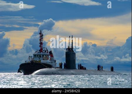 Saipan, United States. 21 October, 2021. The U.S. Navy Los Angeles-class fast attack submarine USS Hampton is assisted by a tug boat to moor at the submarine tender USS Frank Cable for resupply October 21, 2021 in Saipan, Northern Mariana Islands.  Credit: MC2 Chase Stephens/U.S. Navy/Alamy Live News Stock Photo