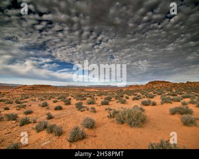 Cotton ball-like clouds drift over the remote terrain near the northern Arizona town of Page. Stock Photo