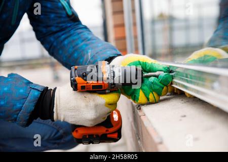 The wizard is engaged in installing windows. Repair work Stock Photo