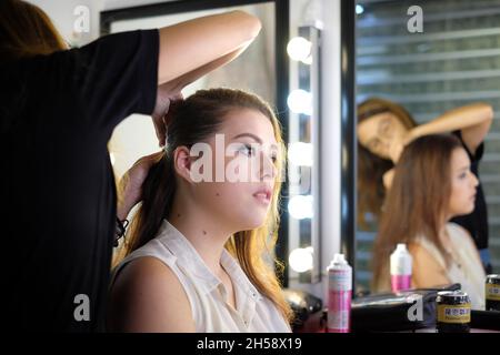 Hairstylist fixes model's hair Stock Photo