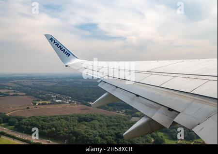 06/09/2021. Commercial Ryanair airborne airplane at high altitude. Cabin window view at wing with trademark name. Stock Photo