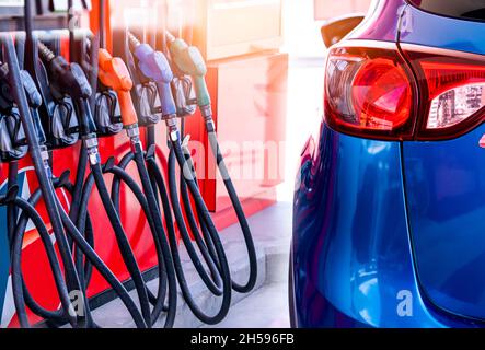 Blue luxury SUV car fueling at gas station. Refuel fill up with petrol gasoline. Petrol pump filling fuel nozzle in gas station. Petrol industry Stock Photo