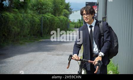 Businessman in business suit riding on bicycle lane to work on urban city street in the morning. Stock Photo