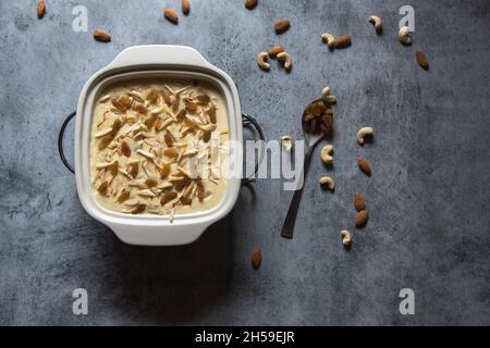 Popular Indian dessert kheer or rice pudding prepared by boiling rice, sugar and milk and garnished with dry fruits and saffron. Stock Photo