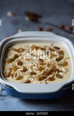 Popular Indian dessert kheer or rice pudding prepared by boiling rice, sugar and milk and garnished with dry fruits and saffron. Stock Photo