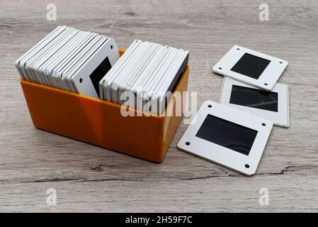 Old slides in a plastic box. Vintage 35mm slide film on wooden table. Stock Photo
