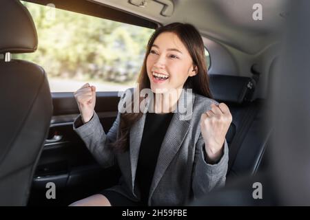 cheerful successed young business woman sitting at the back seat of car Stock Photo