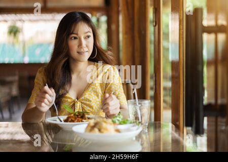 young woman eating spaghetti food in restaurant Stock Photo