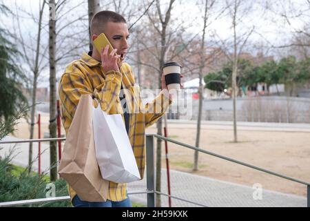 Young man with makeup on surprised speaking on the smartphone. Stock Photo