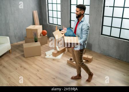 High angle view of happy young man holding packing boxes moving home, new living concept. Stock Photo