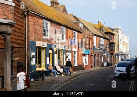 Row of shops, restaurants, cafes & people sitting outside Cafe Zara at tables in sunny autumn High Street Rye East Sussex England UK  KATHY DEWITT Stock Photo