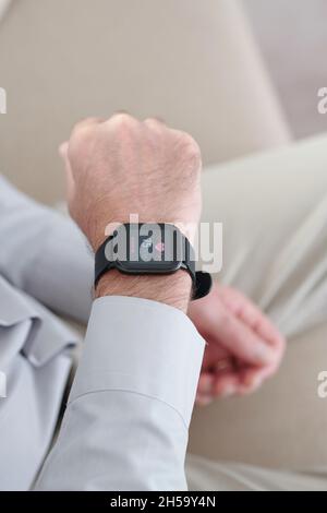 Closeup image of mature man checking heart rate via application on smart watch Stock Photo