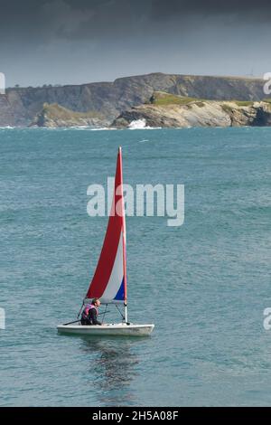 A lone male sailing a Laser Pico in Newquay Bay in Cornwall. Stock Photo