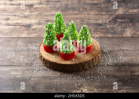 Christmas tree cupcakes on wooden table Stock Photo