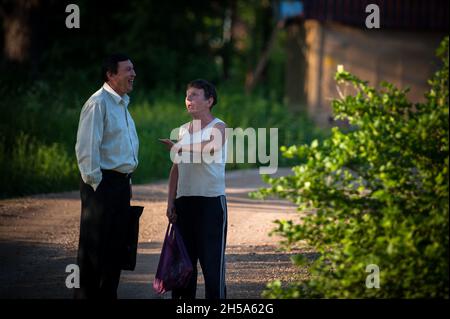 BOROVSK, RUSSIA - MAY 31 2013: A man and an alcoholic woman chatting on the street. Stock Photo