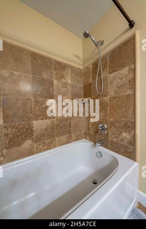 Bathtub with wall mounted handheld shower head and faucet Stock Photo