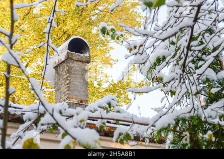 A brick chimney for stove heating on the roof of a house. Wood heating, beginning of the heating season in cold weather. Stock Photo