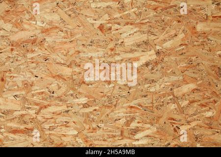 Wood (wooden) surface, texture, background. Building board made from pressed wood chips. A wall with a chaotic pattern created by press machines Stock Photo