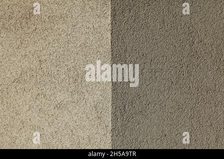 Grey and light-gray wall texture, background. Structural plaster, uneven surface. The corner of a wall or building. Abstract two-component background Stock Photo